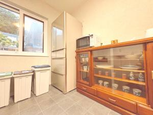 a kitchen with a refrigerator and a microwave at Hitori Otaru in Otaru
