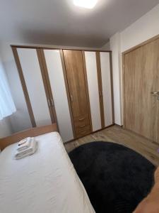 a bedroom with a bed and wooden cabinets at Apartman Simikic in Lopare