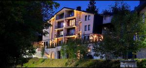 a large white building on a hill at night at D & O Apartments in Mavrovo