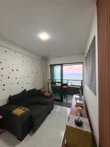 a living room with a couch and a large window at Summer house in Olinda