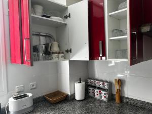 a kitchen with red cabinets and a counter top at Alta-Home cabo in Cabo Negro