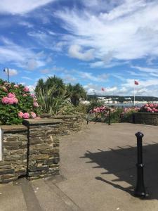 a garden with pink flowers and a stone wall at Downshire House in Douglas