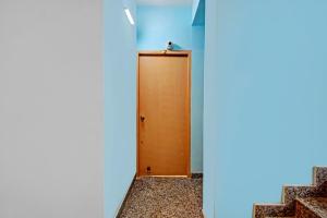 a brown door in a blue room with stairs at Hotel O Casa Astra in Salua