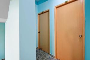 two brown doors in a room with blue walls at Hotel O Casa Astra in Salua