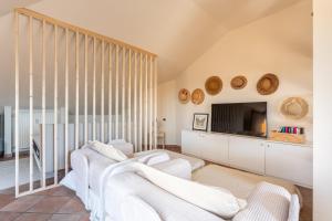 a living room with two white couches and a tv at Maison Blanche in Bordighera