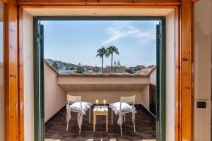 a balcony with a table and chairs on a roof at Maison Blanche in Bordighera