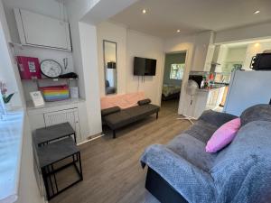 a living room with a couch and a bed at London Heathrow Hayes Escape in South Ruislip Station