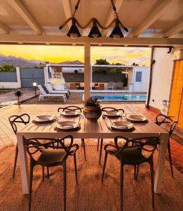 a table and chairs in a patio with a pool at Villa Sidoti in Calatabiano