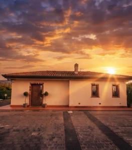 a white house with a sunset in the background at Villa Sidoti in Calatabiano