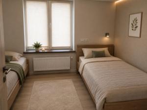 ein Schlafzimmer mit zwei Betten und einem Fenster in der Unterkunft Шариф in Sumy