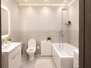 ein weißes Badezimmer mit Toilette und Badewanne in der Unterkunft Шариф in Sumy