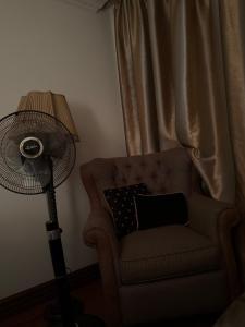 eine Lampe und ein Stuhl mit Kissen und Ventilator in der Unterkunft Шариф in Sumy