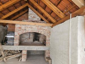 a brick fireplace in a room with a wooden ceiling at Plitvice House Lina in Rakovica