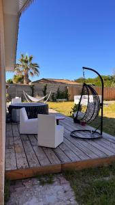 a patio with a swing and a table and chairs at Villa Cazaux in La Teste-de-Buch