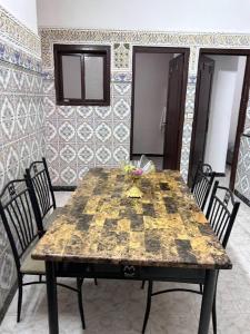 a wooden table with chairs in a room at Meknès,hameriya in Meknès
