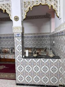 a bathroom with a sink and a tiled wall at Meknès,hameriya in Meknès