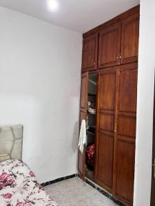 a bedroom with a wooden cabinet and a bed at Meknès,hameriya in Meknès