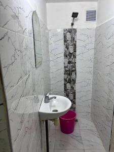 a white bathroom with a sink and a mirror at Meknès,hameriya in Meknès