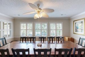 a dining room with a table and a ceiling fan at Meant To Beach in Edisto Beach