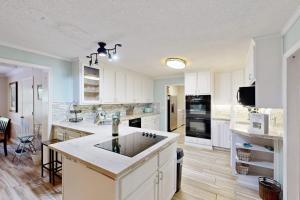 a large kitchen with white cabinets and a large island at Meant To Beach in Edisto Beach