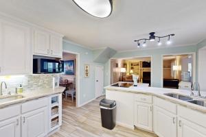a large kitchen with white cabinets and a kitchen island at Meant To Beach in Edisto Beach