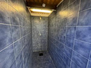 a bathroom with blue tiled walls and a shower at Nurral - TENT in Fertilia