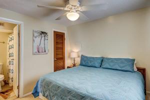 a bedroom with a blue bed and a ceiling fan at Driftwood Villa - 237 in Edisto Beach