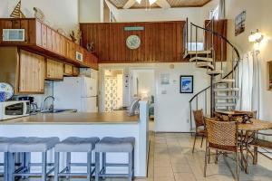 a kitchen with a counter top and a spiral staircase at Driftwood Villa - 237 in Edisto Beach
