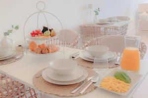 a table with plates and bowls of fruit and orange juice at HOTEL SLOW STAY - Esposende in Esposende
