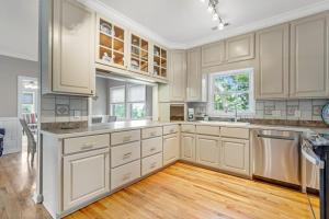 a large kitchen with white cabinets and wooden floors at Sto-Away in Edisto Beach