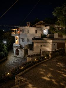 ein weißes Haus mit Lichtern davor bei Nacht in der Unterkunft Vila Drasa Guesthouse in Gjirokastër