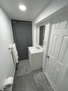 a white bathroom with a sink and a mirror at Lg2NY in Westerleigh