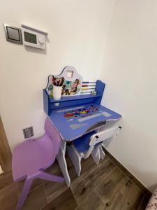 a table and a pink chair in a room at Apartman Simikic in Lopare