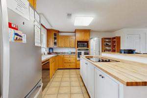 a kitchen with wooden cabinets and a white refrigerator at The Answer in Edisto Island +14 photos