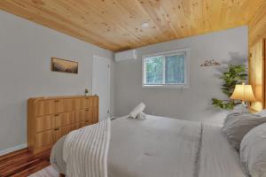 a bedroom with a white bed and a wooden ceiling at Private Cozy Cabin with Fire Pit in Locust Lakes Village