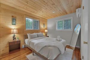 a bedroom with a large bed with wooden walls at Private Cozy Cabin with Fire Pit in Locust Lakes Village