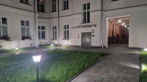 a courtyard of a building with green grass at BOOGIE Home Nawrot 13 in Łódź