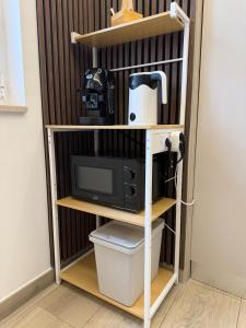 a shelf unit with a microwave and a tv at Cagrovi Apartments in Casoria