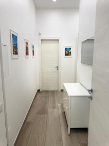 a white room with a white door and a sink at Cagrovi Apartments in Casoria