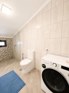 a washing machine in a bathroom with a toilet at Vista Sol in Bicas +12 photos