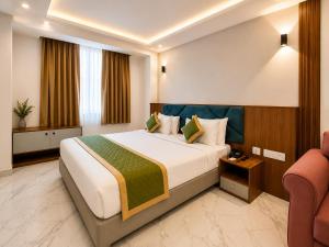 a hotel room with a bed and a chair at Sabu's Grand Royale - Thampanoor in Trivandrum