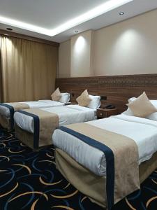 a hotel room with two beds in a room at Nuzul Nebras Al Madinah in Medina