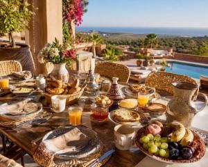 a table with food on it with a view of a pool at Villa Lala Argana in Essaouira