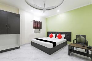 a bedroom with a bed with red pillows and a table at Hotel O Figtree Premier in Patna