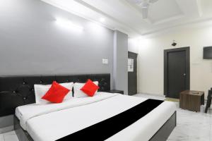 a bedroom with a large bed with red pillows at Hotel O Figtree Premier in Patna