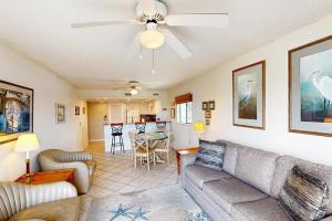 a living room with a couch and a ceiling fan at Bay Creek Villa - 202 in Edisto Beach