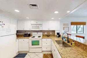 a white kitchen with a sink and a stove at Bay Creek Villa - 202 in Edisto Beach +20 photos