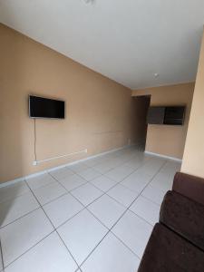 an empty room with a flat screen tv on the wall at Duplex Arretadinho in Aquiraz