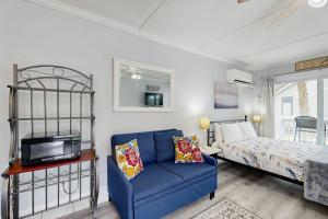 a living room with a blue couch and a bed at Sea La Vie in Edisto Island