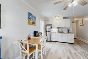 a kitchen with white cabinets and a table and chairs at Sea La Vie in Edisto Island